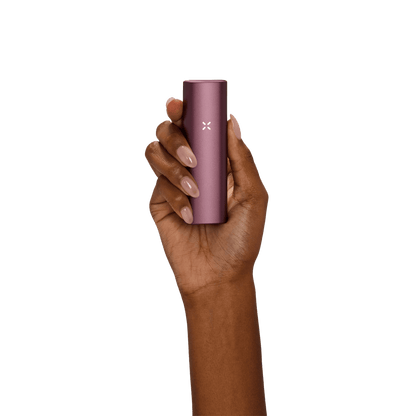 Alt Tag: Halte den PAX Plus Vaporizer in Elderberry Pink in deiner Hand für stilvolle Dampfsessions unterwegs.